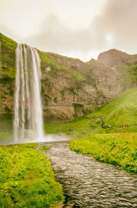 Scenic view of waterfall against sky