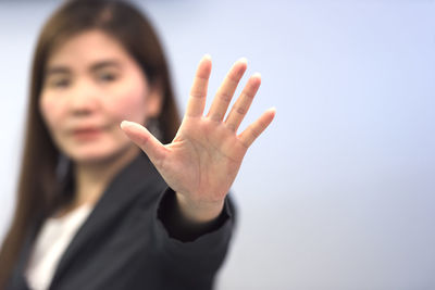 Close-up of woman with hand in background