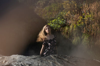 Portrait of young woman amidst trees