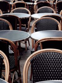 Empty chairs and tables at sidewalk cafe