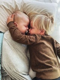 High angle view of two small children lying on bed at home