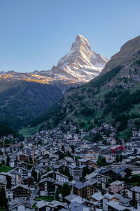 Aerial view of townscape and mountains against clear sky