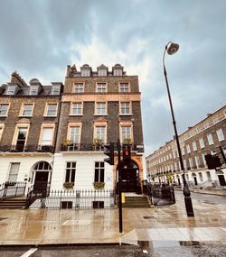 Low angle view of buildings against cloudy sky