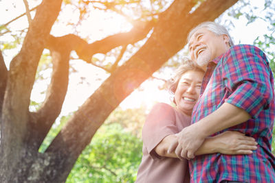 Rear view of couple kissing against trees