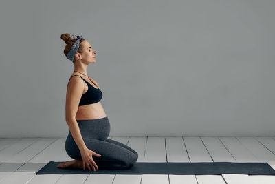 Full length of woman standing against wall