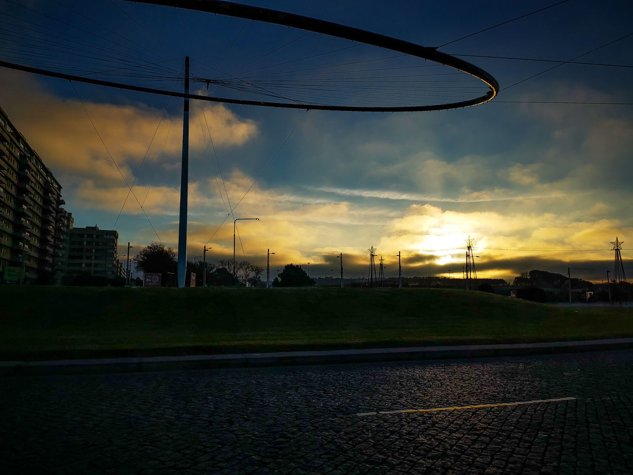 STREET BY CITY AGAINST SKY AT SUNSET