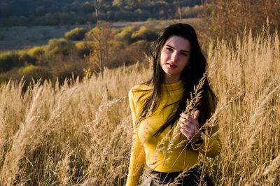 Portrait of beautiful woman amidst plants on field