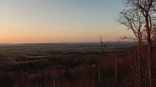 Scenic view of field against clear sky during sunset