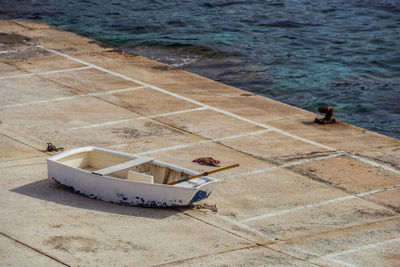 Rowboat on footpath at harbor