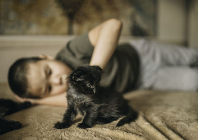Portrait of an asian boy lying sad with a kitten