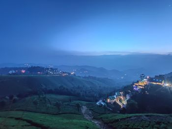 High angle view of illuminated houses against sky at night