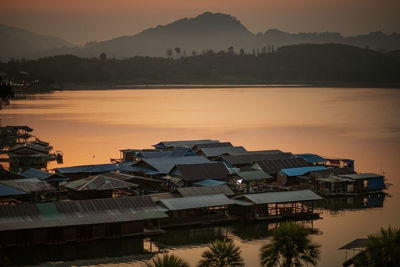 High angle view of lake by buildings against sky during sunset