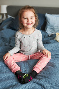 Smiling girl sitting on bed