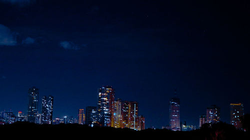 Illuminated buildings against sky at night