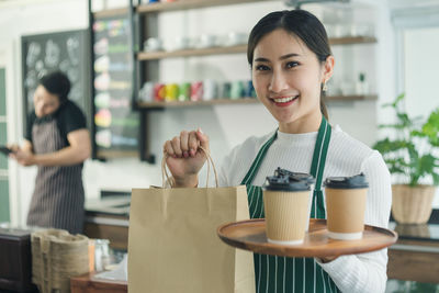 Portrait of a smiling young woman holding food