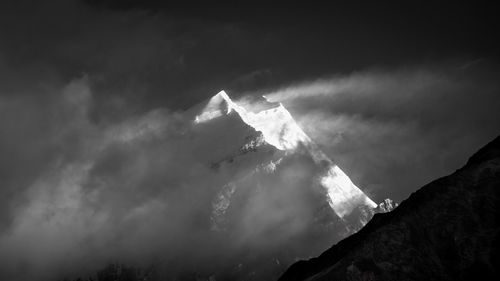 Low angle view of snowcapped mountains against sky