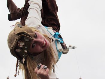 Portrait of smiling young woman against sky