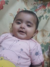 High angle view of cute baby lying on bed at home