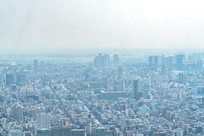 Aerial view of buildings in city against sky