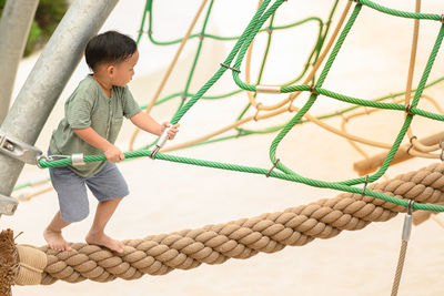 Full length of boy standing on rope