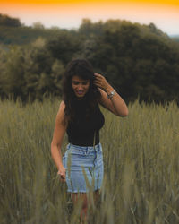 Smiling young woman standing on field