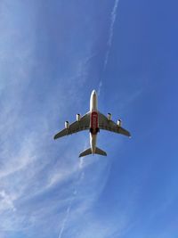 Low angle view of airplane flying against sky