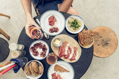 Midsection of person having food and drink at table