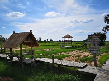 Built structure on field by houses against sky