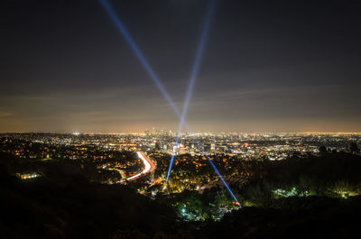 Illuminated cityscape against sky at night