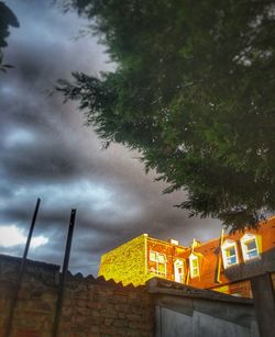 Low angle view of trees and building against sky