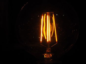 Close-up of lit candle in dark room