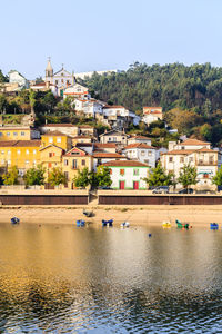 Buildings by river against sky