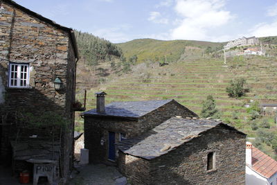 Old building by mountain against sky