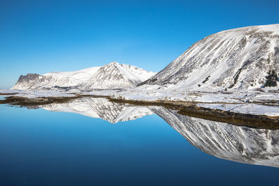 Scenic view of snowcapped mountains against clear blue sky