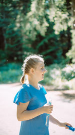 Side view of girl looking away while standing outdoors