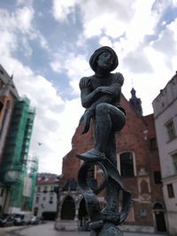 Low angle view of statue against buildings