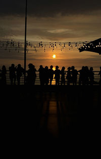 Silhouette people at beach during sunset