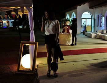 Full length of man standing in illuminated corridor