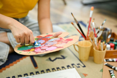 Midsection of woman painting on table