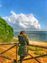 Rear view of woman looking at sea against sky