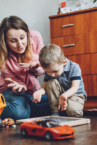 Mother playing with son at home