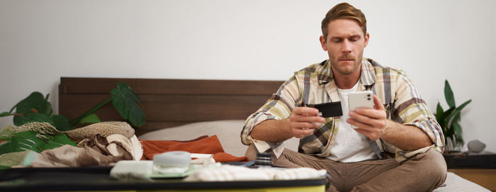 Portrait of senior man using mobile phone while sitting at home