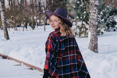 Young woman enjoying winter weather in the snow park. cold weather. winter fashion, holidays, rest