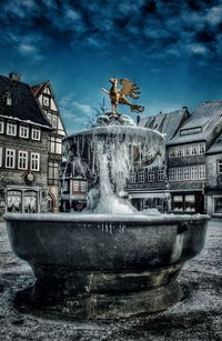 Statue by water against sky