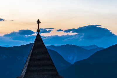 Low angle view of cross on mountain against sky