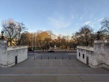 Street amidst trees and buildings against sky