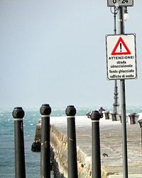 Warning sign on wooden post