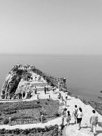 People at seaside against clear sky