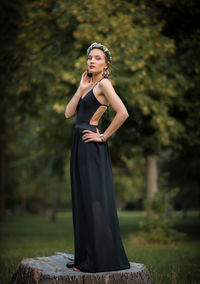 Young woman standing against tree