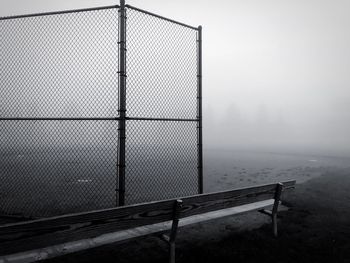 Empty chair against sky during foggy weather